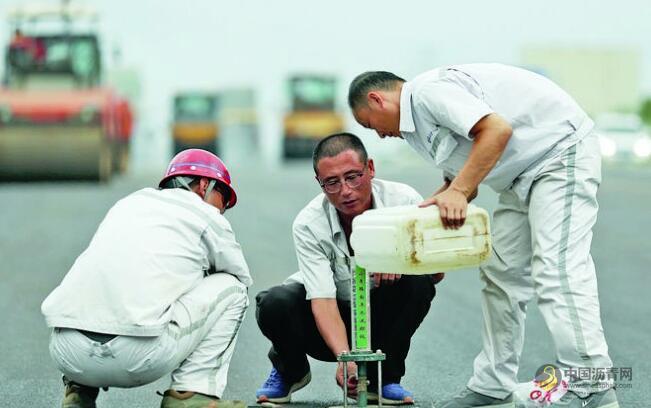 玉林市民主南路改扩建 工人在160℃沥青上铺路 沥青网，sinoasphalt.com